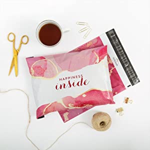 Pink poly mailer flat lay with scissors, coffee, and twine.