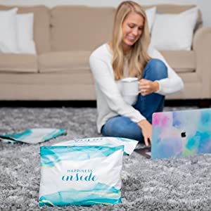 Woman in her living room with blue poly mailer packaging.